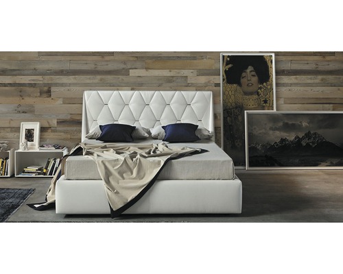 Bett mit gestepptem Kopfteil, Nachttisch und Bildern im Schlafzimmer