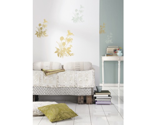 Dekoratives Wohnzimmer mit Blumen Wandtattoos, Palettenbett und Vintage-Radio auf einem Tisch