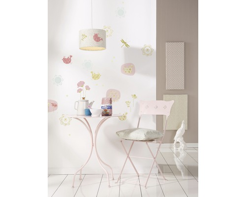 Chambre avec table, chaise, lampe et décorations murales pour enfants.