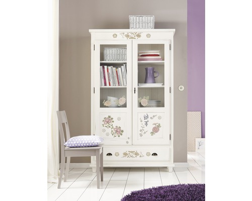 Vitrine décorative avec des éléments floraux dans une pièce lumineuse.