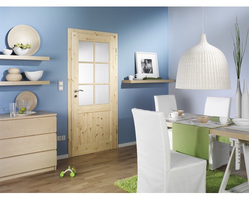 Helles Wohnzimmer mit Holztür, Esstisch und Stühlen