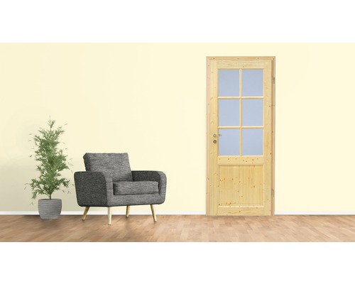 Wohnszene mit Holztür mit Glaseinsatz, Sessel und Zimmerpflanze