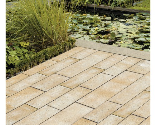 Verlegte rechteckige Pflastersteine im Garten mit Teich