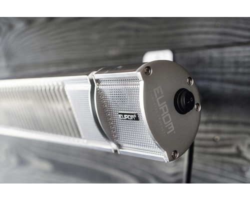 Nahaufnahme einer montierten, silberfarbenen Heizlampe mit Schalter und Firmenlogo