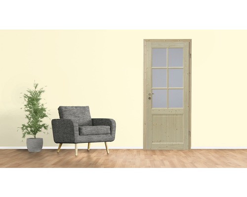 Holztür mit Glaseinsatz neben Sessel und Zimmerpflanze
