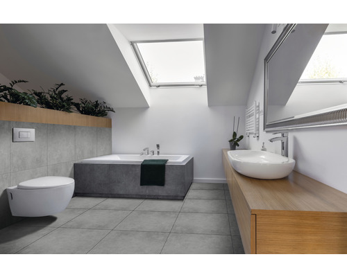 Salle de bains moderne avec fenêtre de toit, baignoire, lavabo, miroir et WC suspendu