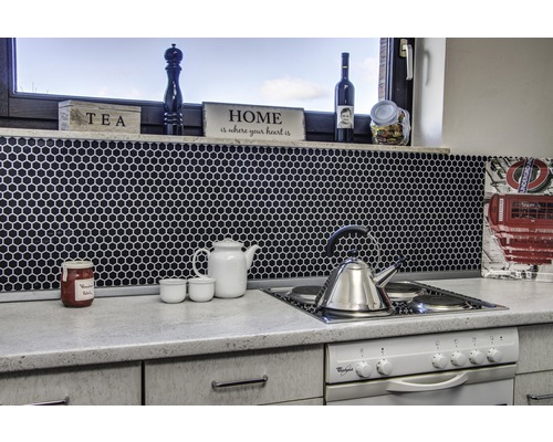Scène de cuisine avec des carreaux de mosaïque, une théière, une bouilloire et une plaque de cuisson.
