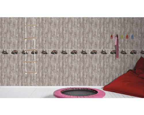 Chambre d''enfant avec papier peint imitation bois et bordure tracteur, échelle de corde et pouf rouge