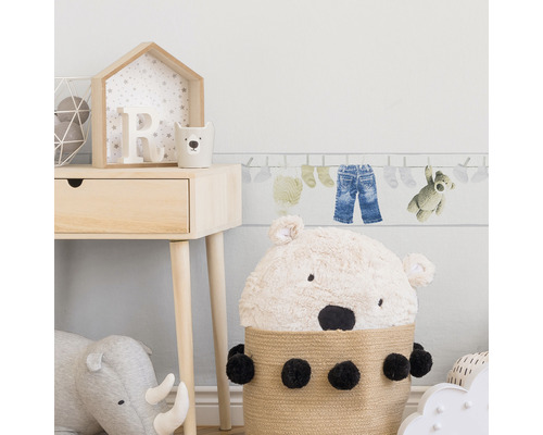 Scène de chambre d''enfant avec commode en bois, panier de rangement ours en peluche et bordure murale sur le thème de la corde à linge