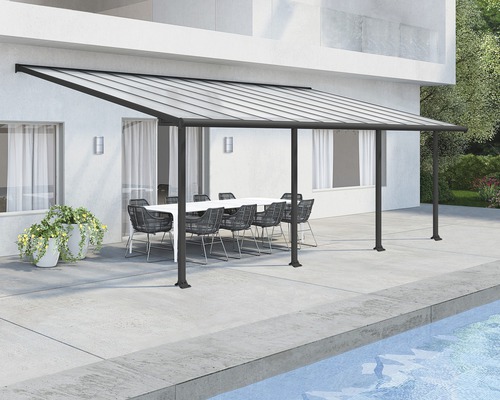 Terrassenüberdachung Palram – Canopia Olympia 3x7.3 739 x 295 cm RAL7016 grau Terrassenüberdachung mit Tisch und Stühlen im Außenbereich.