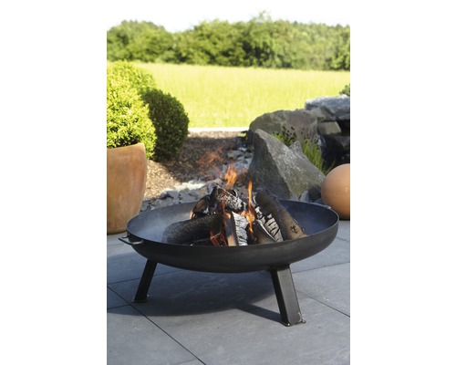 Braséro avec du bois qui brûle dans le jardin