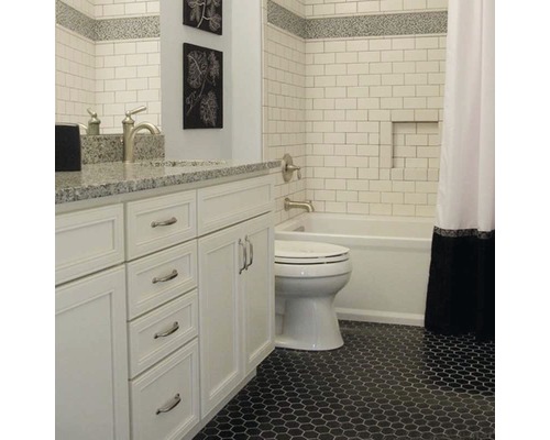 Badezimmer mit weißem Waschtisch, Toilette, Badewanne und sechseckigen Bodenfliesen