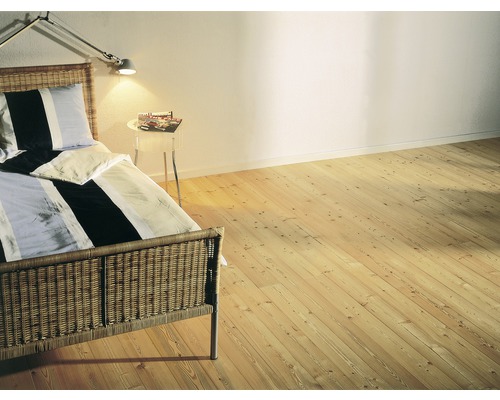 Chambre à coucher avec plancher en bois, lit et table de chevet.