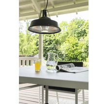 Hängender Heizstrahler über einem Gartentisch mit Getränken und einer Zeitschrift für eine Terrasse im Freien.