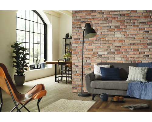 Salon avec canapé, lampadaire et papier peint imitation mur de briques