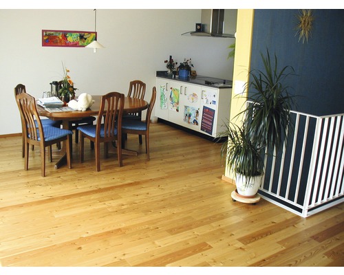 Salon avec plancher en bois, table à manger et kitchenette