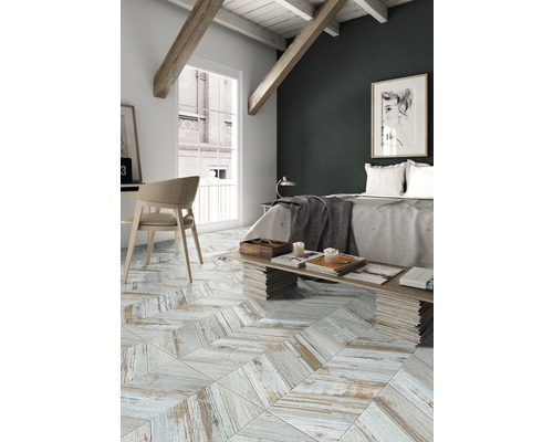 Schlafzimmer mit hellem Holzboden im Fischgrätmuster, Bett und Schreibtisch.