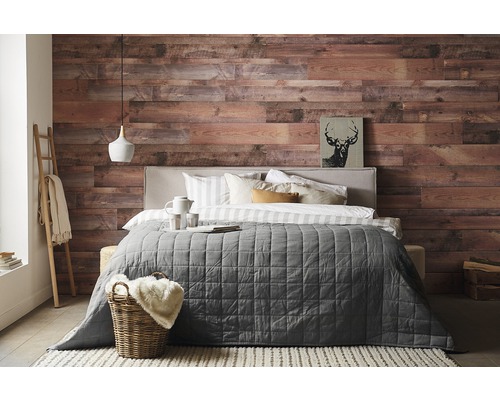 Schlafzimmer mit Holzwand, Bett, Decke und Dekorationen