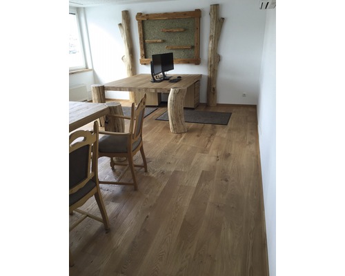 Büro mit Massivholztisch, Baumstamm-Elementen und Holzfußboden
