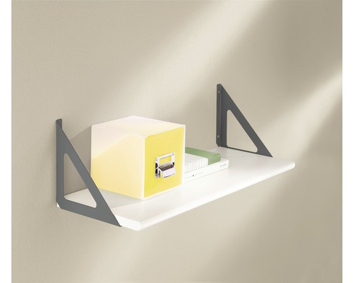 Étagère murale avec des livres et une boîte jaune sur une planche blanche