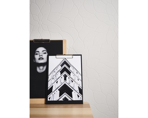 Gemusterte Tapete mit zwei Bildern auf einer Kommode