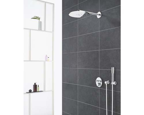 Badezimmer mit Kopfbrause, Handbrause und Aufputzthermostat an gefliester Wand.