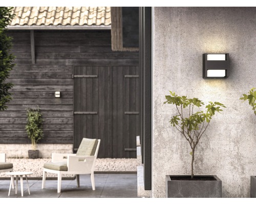 Außenbereich mit quadratischer Wandleuchte, Gartenmöbeln und Bepflanzung
