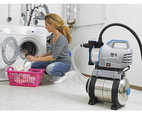 Surpresseur utilisé dans une buanderie à côté d''un lave-linge avec un panier à linge