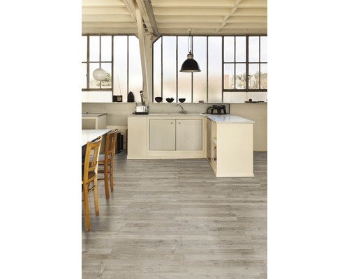 Pièce lumineuse avec kitchenette et parquet en bois.