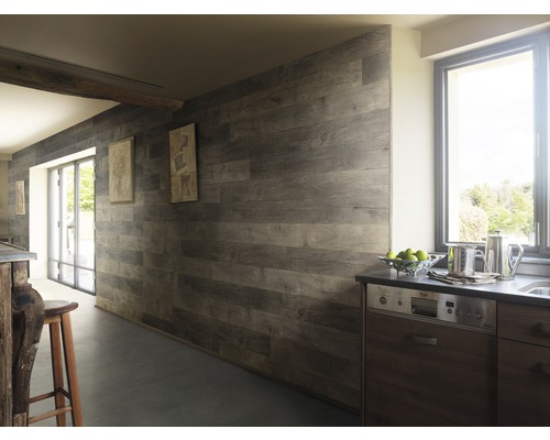 Innenaufnahme eines Zimmers mit Holzpaneelen an der Wand und Fenstern