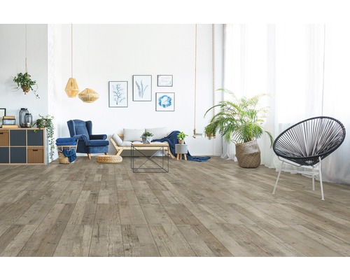 Salon avec plancher en bois brun clair, canapé, fauteuil et décorations pour une ambiance chaleureuse.