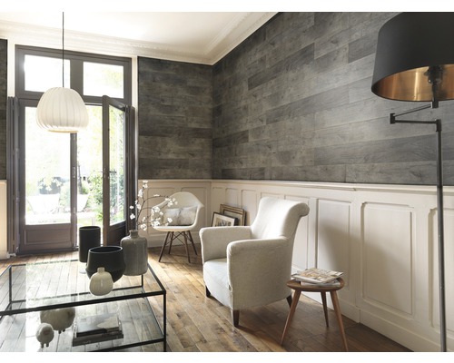 Wohnzimmer mit Holzvertäfelung an der Wand, Sessel und Tisch