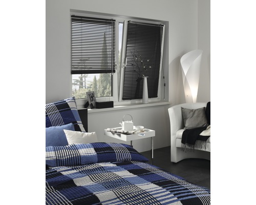 Chambre à coucher avec fenêtre, équipée de stores vénitiens noirs pour le contrôle de la lumière.