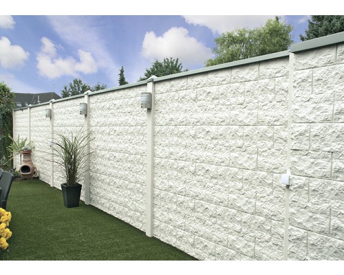 Jardin avec mur en pierre, éclairage et plantes