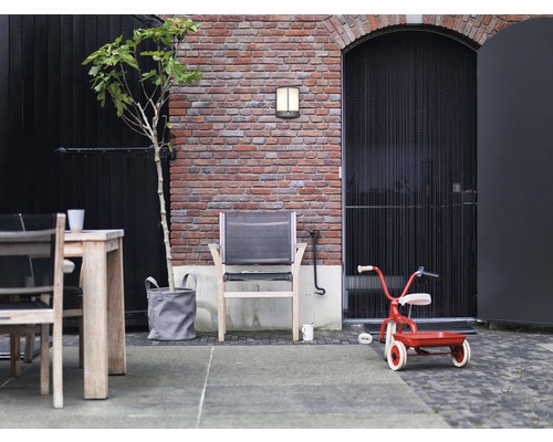 Aussenbereich mit Mauerwerk, Sitzgelegenheiten und Spielzeugdreirad