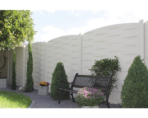 Scène de jardin avec clôture en béton, banc et plantations