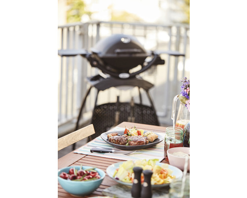 Scène avec un barbecue, une table avec de la nourriture et des boissons sur un balcon.