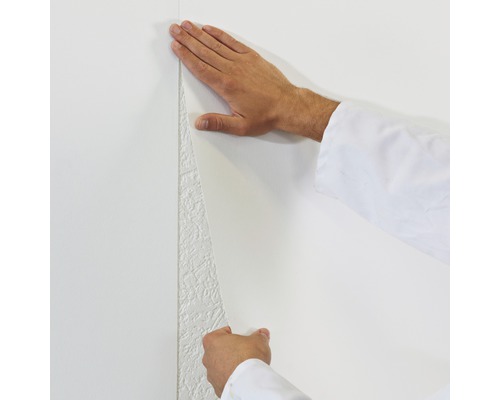 Application d''un papier peint intissé blanc sur un mur