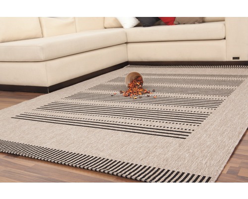 Tapis beige avec des rayures noires et des ornements dans le salon.