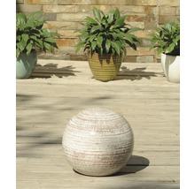 Boule décorative texturée devant des plantes en pot sur une terrasse en bois