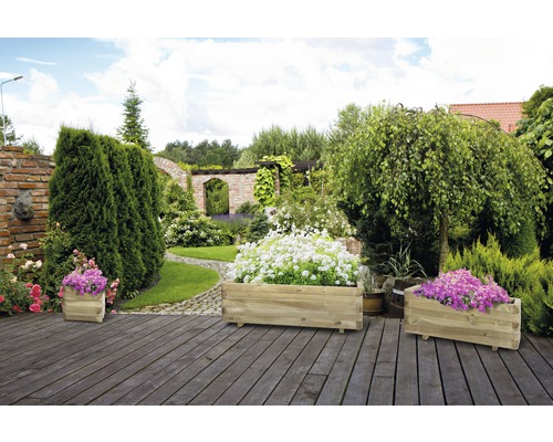 Trois jardinières rectangulaires en bois dans le jardin.