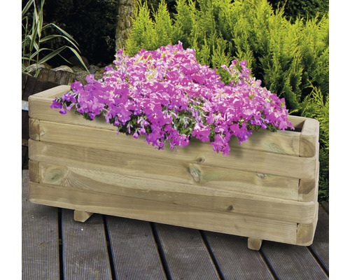 Jardinière en bois avec fleurs sur une terrasse en bois dans le jardin.
