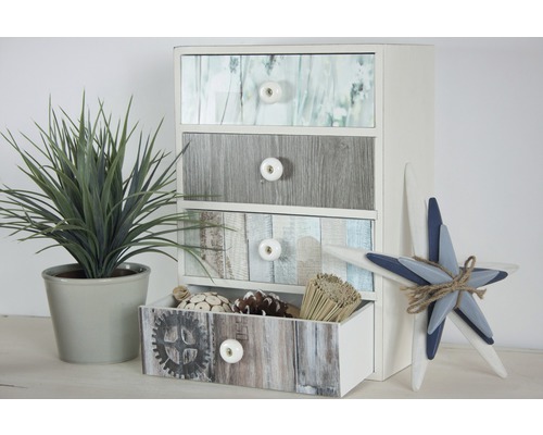 Commode à quatre tiroirs imitation bois à côté d''une plante décorative et d''une étoile décorative