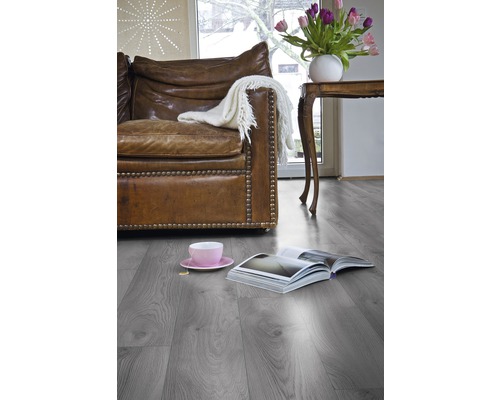 Wohnzimmer mit grauem Laminatboden, Ledersofa und Dekoration