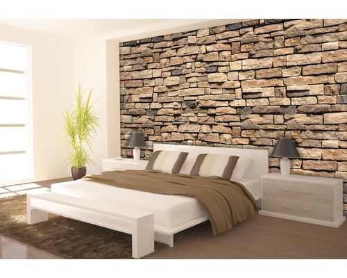 Chambre moderne avec papier peint imitation pierre, lit blanc et tables de chevet