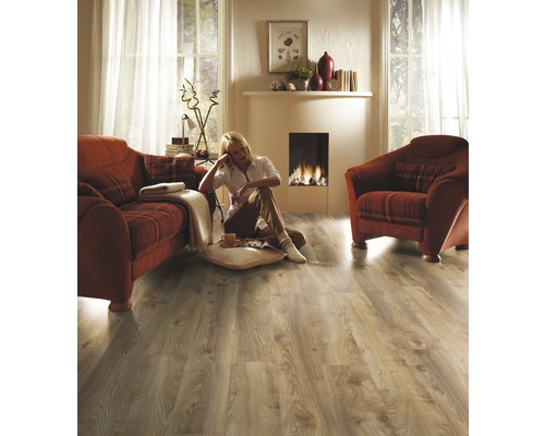 Wohnzimmer mit Laminatboden, Sofa, Sessel und Kamin