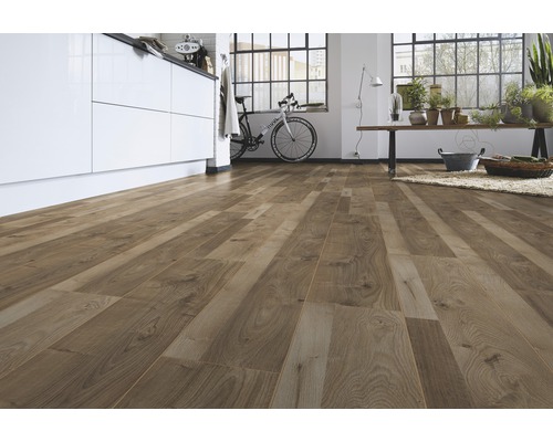 Pièce lumineuse avec sol stratifié imitation bois, kitchenette, vélo et décoration