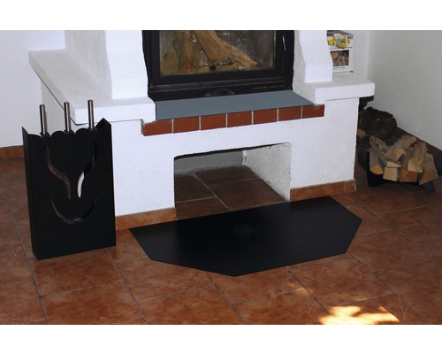 Kamin mit Kaminbesteck und Funkenschutzplatte auf gefliestem Boden