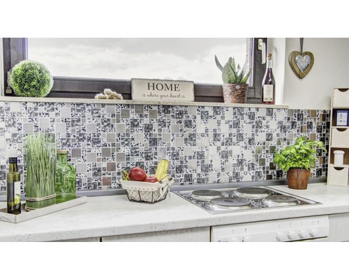 Detailaufnahme einer modernen Küche mit Mosaikfliesen als Spritzschutz, Herd und verschiedenen Dekorationsgegenständen.