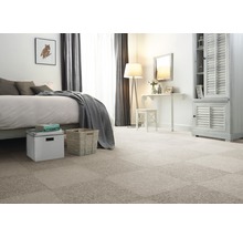 Schlafzimmer mit verlegtem Teppichboden aus einzelnen Teppichfliesen, Bett, Kommode und Sitzgelegenheit